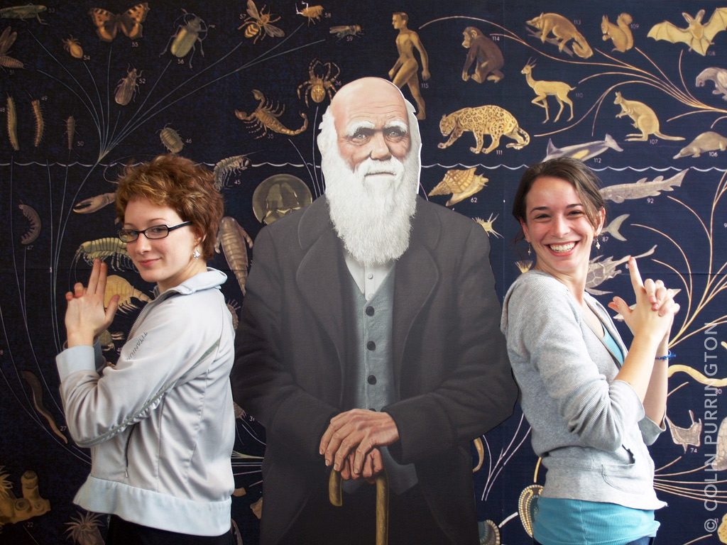 Charles Darwin posing with two angels